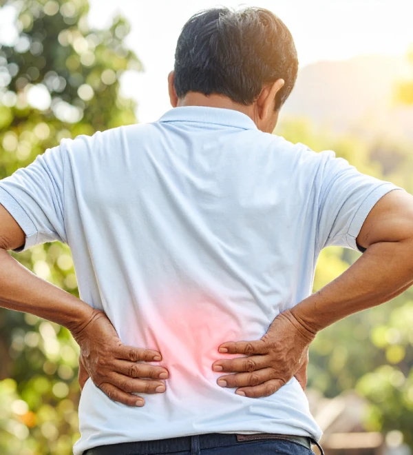 person with back pain holding both sides of their back